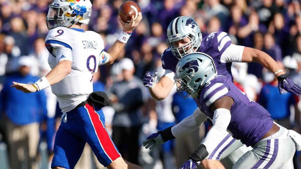 K-State defenders chase Kansas quarterback Carter Stanley in the first half Saturday in Manhattan.