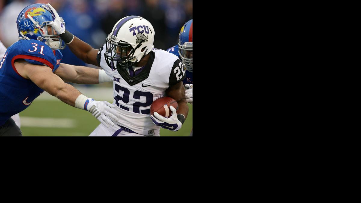
TCU running back Aaron Green tries to fight off Kansas linebacker Ben Heeney during the first half Saturday in Lawrence.
