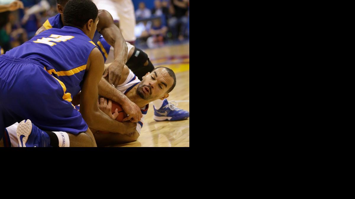 
Kansas forward Perry Ellis, right, goes to the floor with UC Santa Barbara guard Gabe Vincent (2) during the first half of Friday’s game in Lawrence.
