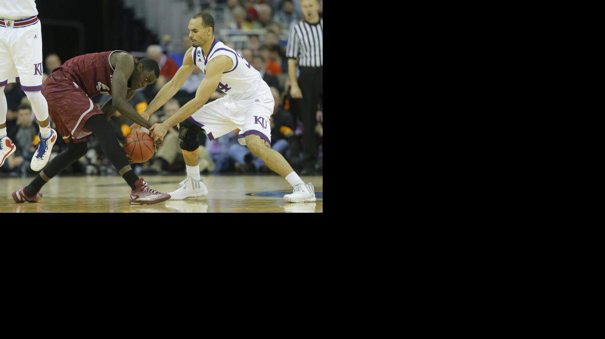 
New Mexico State forward Pascal Siakam and Kansas forward Perry Ellis fight for the ball in the first half Friday in Omaha. Kansas won to advance to Sunday’s third round.
