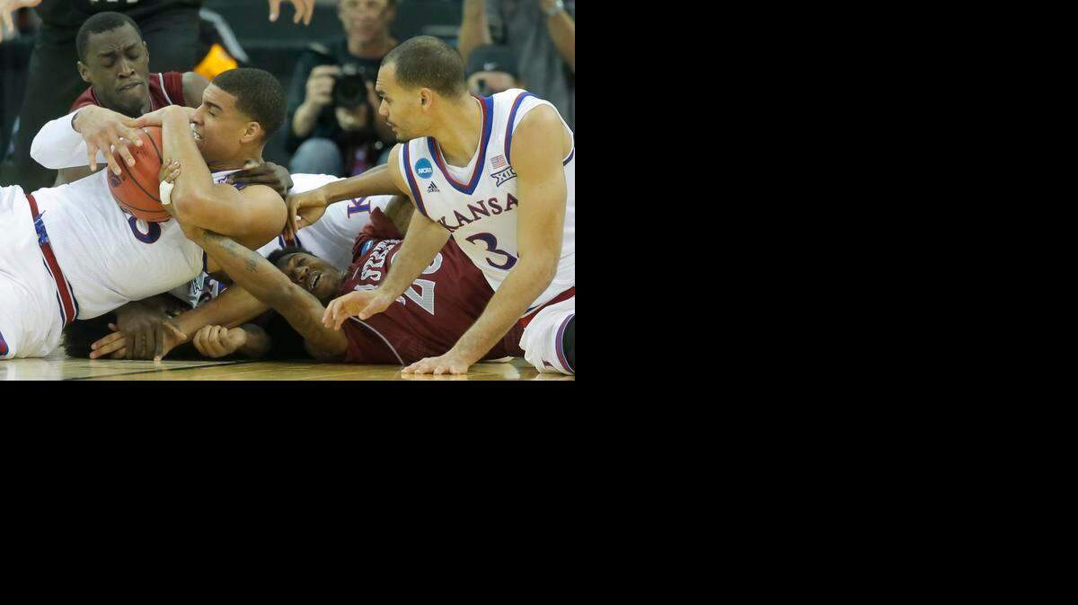 
Kansas forward Landen Lucas holds onto a ball against New Mexico State during the second half of their game in the NCAA Tournament at CenturyLink Center in Omaha.
