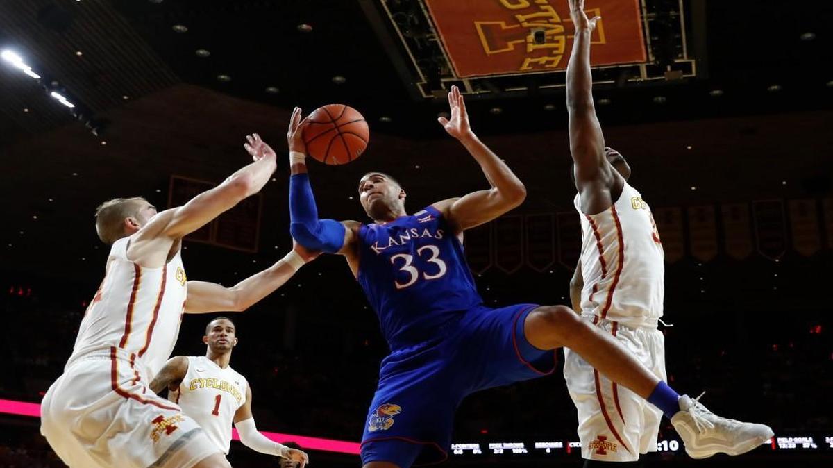 Kansas forward Landen Lucas (33) grabs a rebound between Iowa State's Matt Thomas, left, Nick Weiler-Babb (1) and Deonte Burton, right, during the first half Monday night at Hilton Coliseum.