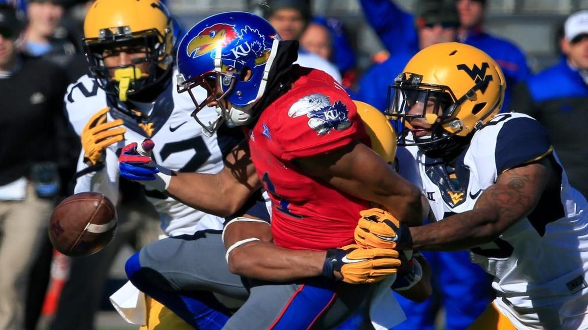 Kansas wide receiver Tre’ Parmalee fumbles when hit by West Virginia cornerback Terrell Chestnut and safety Dravon Askew-Henry, right, during the first half Saturday in Lawrence.