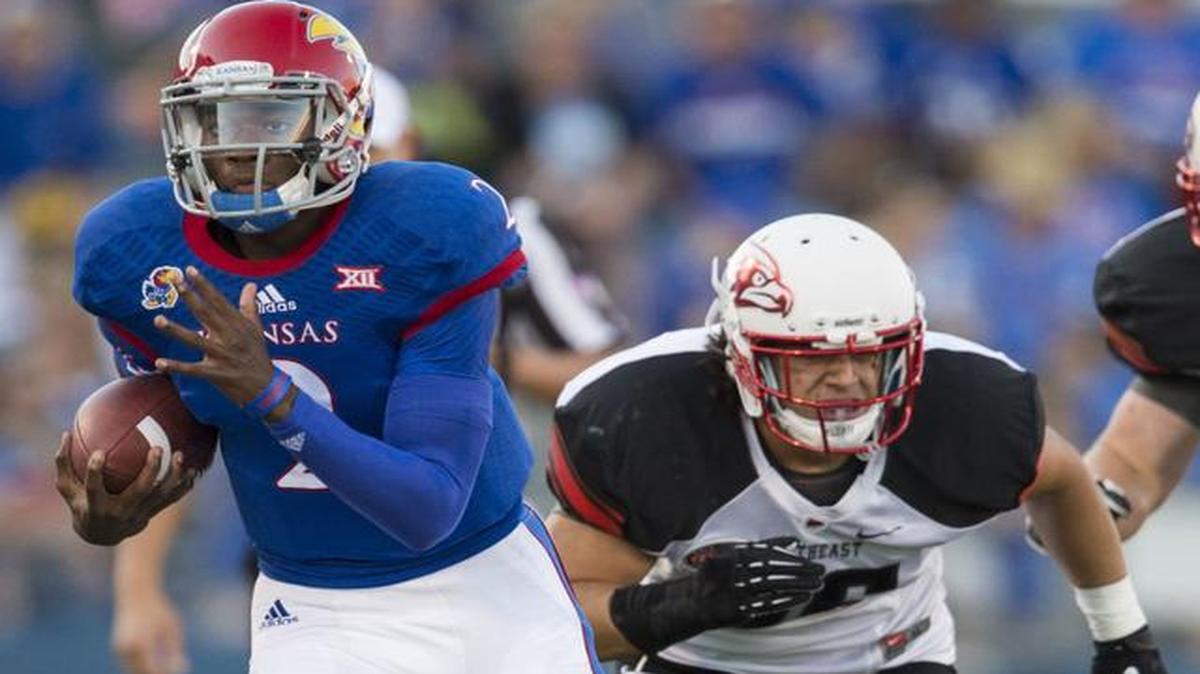 
Kansas quarterback Montell Cozart, left, picks up some yards after shaking Southeast Missouri State safety Eriq Moore on Saturday.
