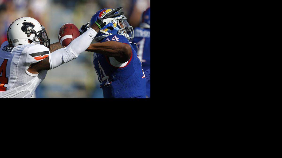 
Oklahoma State safety Dylan Harding forces a fumble by Kansas quarterback Michael Cummings during the first half Saturday.
