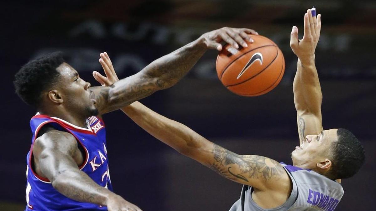 Kansas forward Jamari Traylor, left, knocks down a shot by K-State guard Justin Edwards late in the first half Saturday in Bramlage Coliseum.