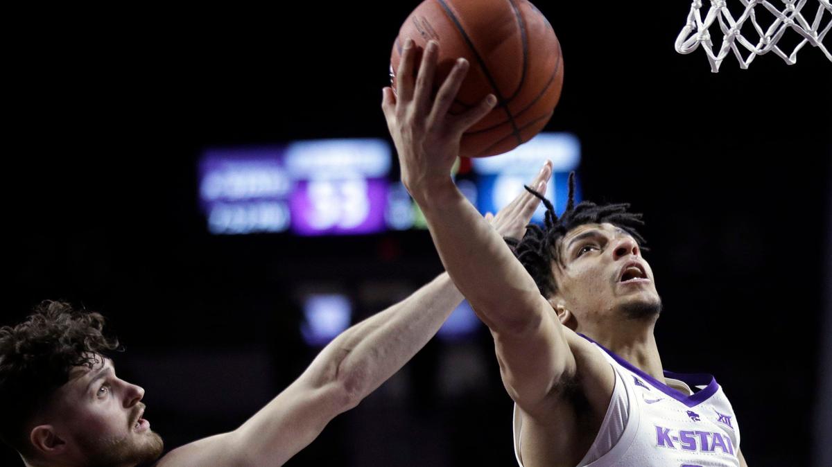 Kansas State guard Mike McGuirl (00) gets past West Virginia guard Chase Harler (14) for a basket during the second half of an NCAA college basketball game in Manhattan, Kan., Wednesday, Jan. 9, 2019. (AP Photo/Orlin Wagner)