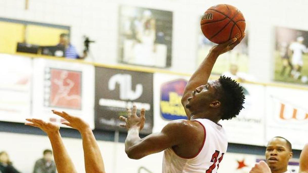 Newman’s James Pegues, right, avoids a foul as he puts up a shot against Pittsburg State on Tuesday.