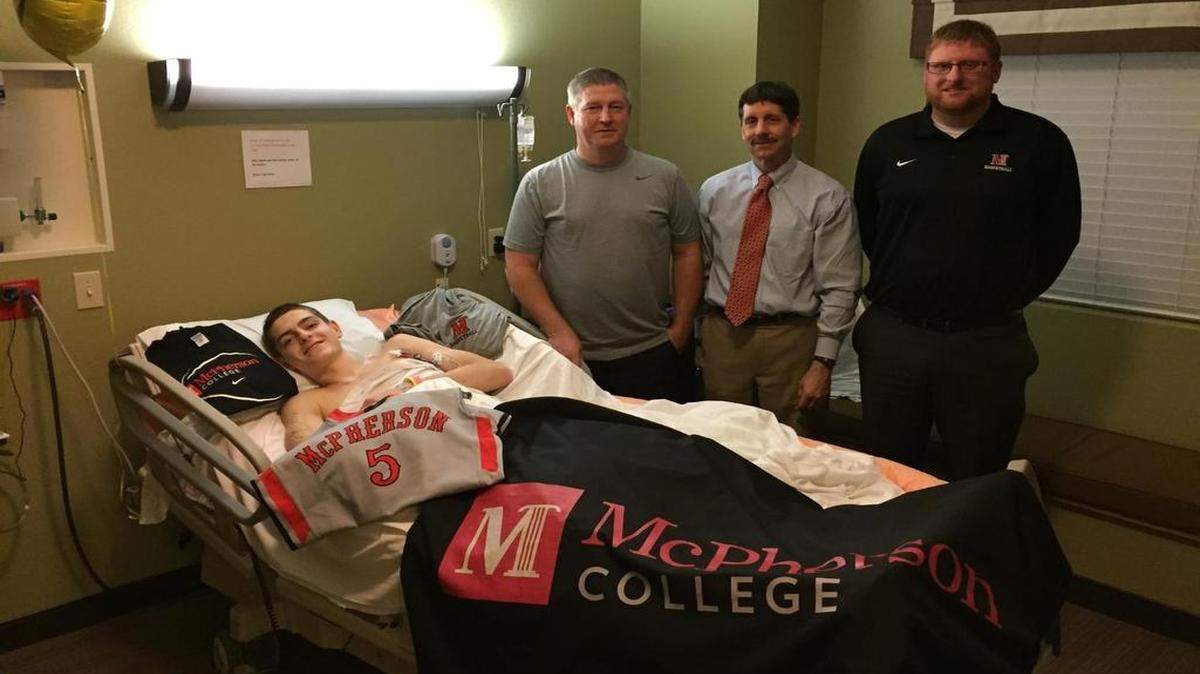 
Hesston senior Grant Raleigh signed Wednesday with McPherson College — from his hospital bed in Colorado. Raleigh was in a skiing accident last month and has yet to leave the hospital. His dad, Greg (standing left), and McPherson College coach Tim Swartzendruber (standing in the middle) and assistant T.J. Eskildsen are with Raleigh.
