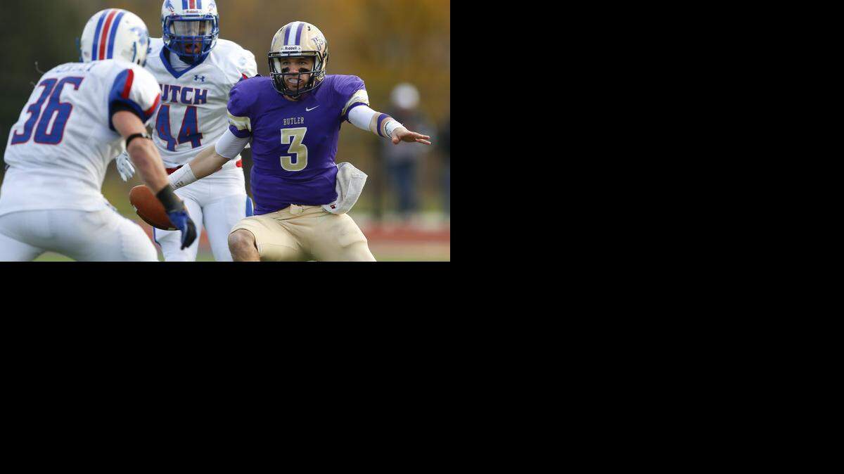 
Butler quarterback Hunter Vaughn runs between two Hutchinson defenders last November.
