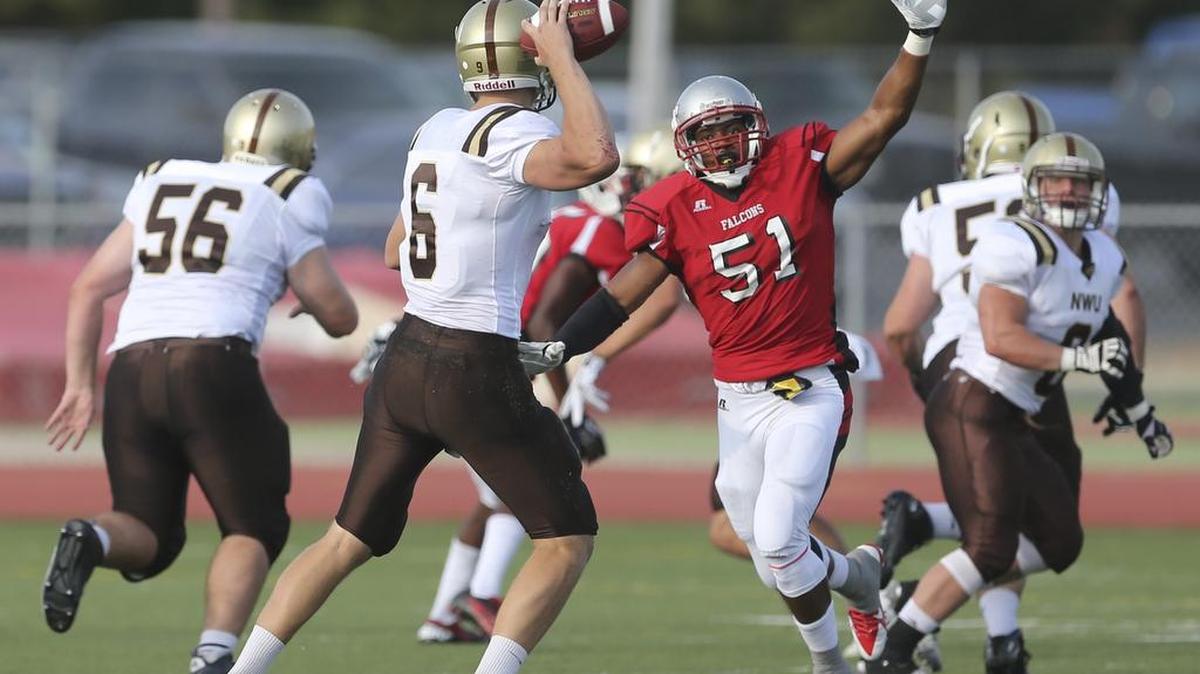 
Nebraska Wesleyan quarterback Ben Green is pressured by Friends linebacker Bryce Johnson during the first quarter Saturday night.
