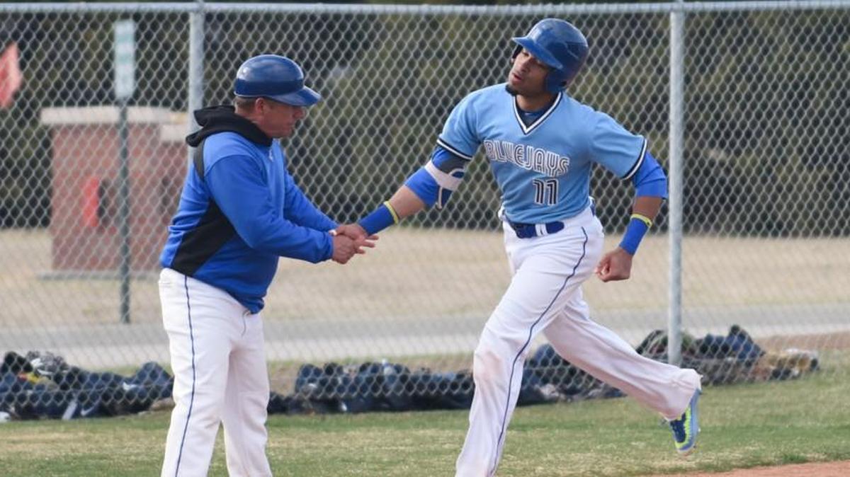 Tabor College outfielder Manny DeLeon is congratulated by coach Mark Standiford after hitting a home run this season. DeLeon was named the NAIA Player of the Year on Tuesday.