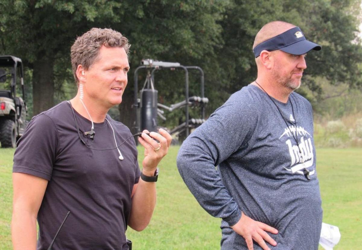 Coach Jason Brown (right) and “Last Chance U” director Greg Whiteley watched an Independence Community football practice. Brown resigned in February.