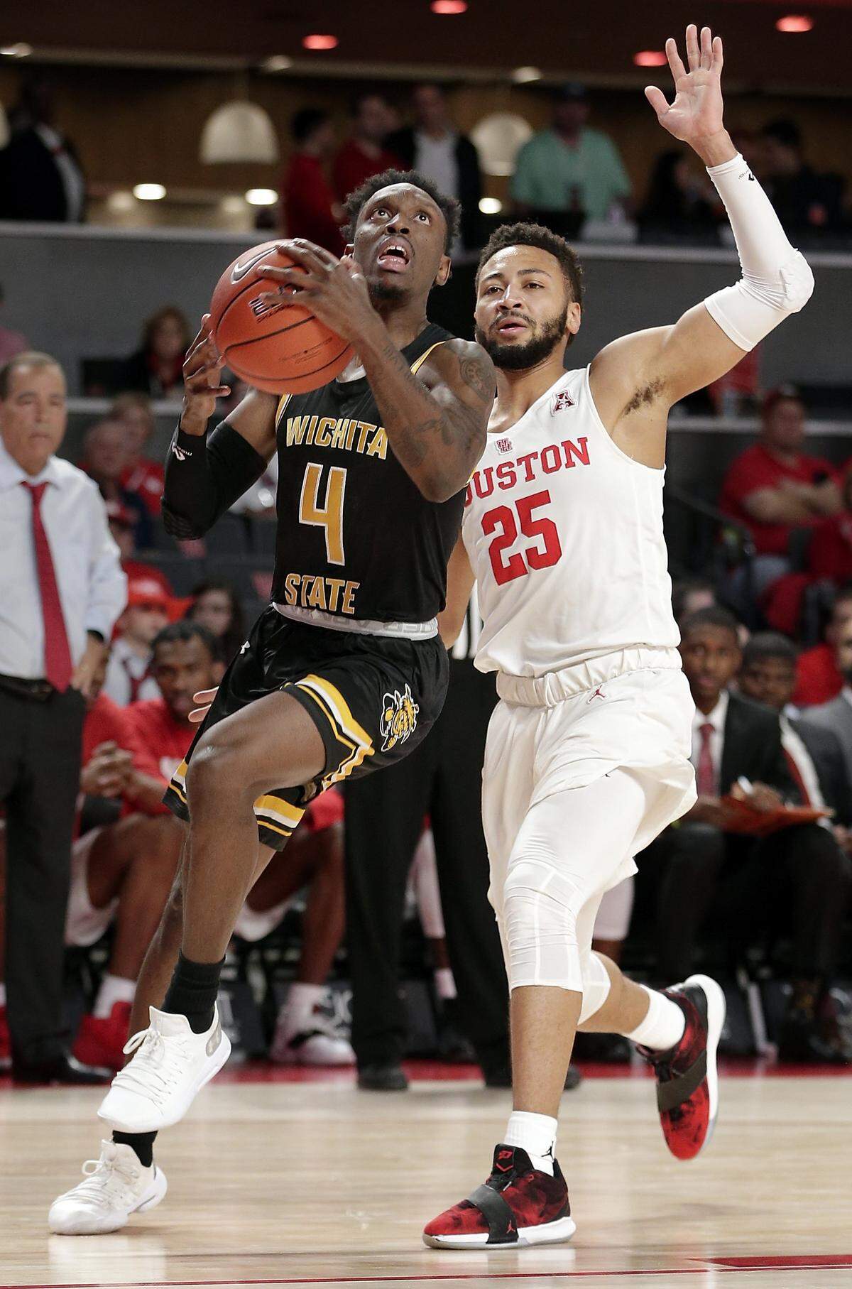 Wichita State guard Samajae Haynes-Jones (4) drives to the basket with Houston guard Galen Robinson Jr. (25) behind during the first half Saturda in Houston.