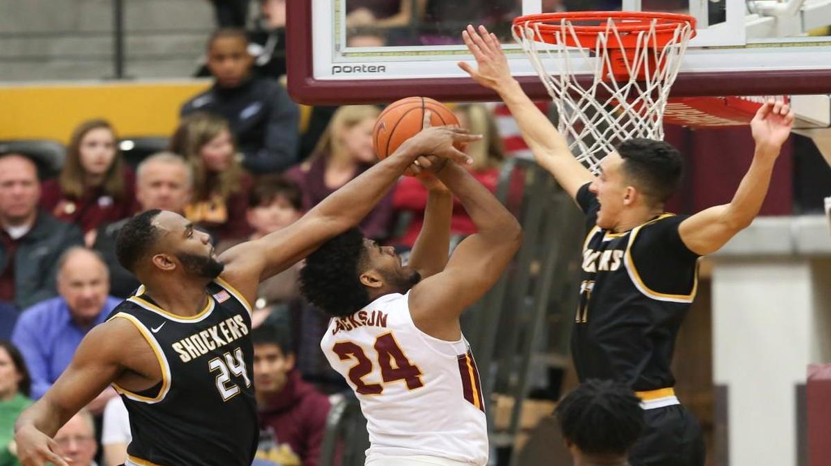 Wichita State’s Shaquille Morris, left, and Landry Shamet, right defend Loyola’s Aundre Jackson during the first half Sunday in Chicago.