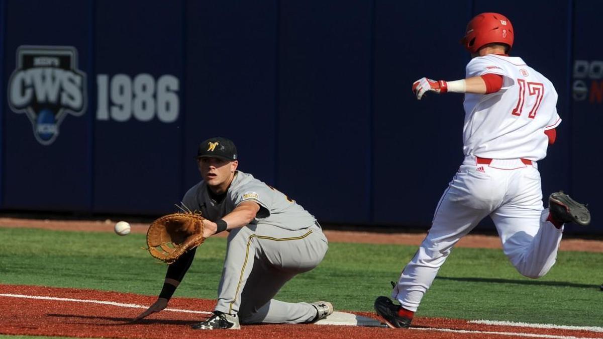 Wichita State first baseman Greyson Jenista awaits a throw as Bradley’s Luke Mangieri reaches the bag during the Shockers’ 5-2 loss on Wednesday in the first round of the MVC Tournament.