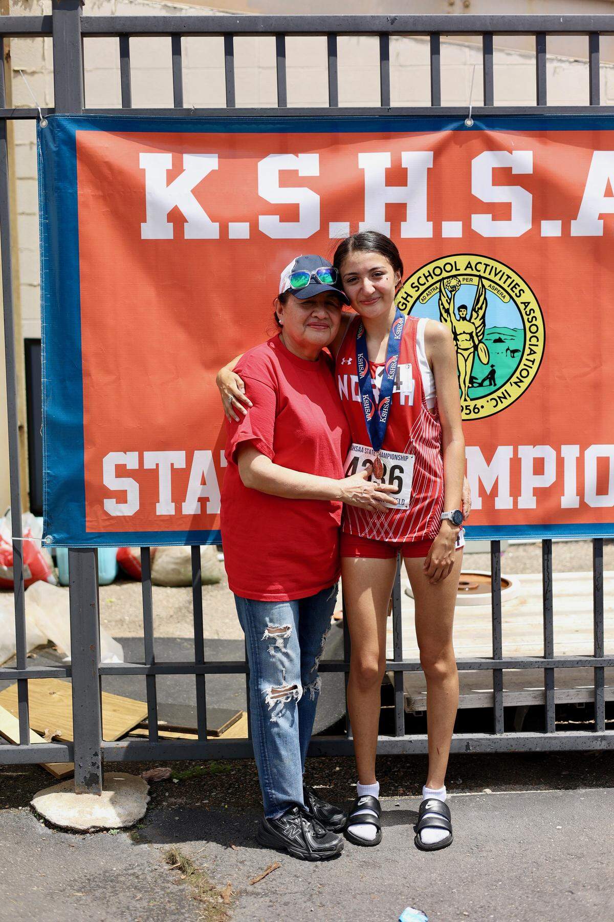 Wichita North senior Nelly Puente poses with her mother, Elida, after winning the Class 6A girls 1600-meter title and becoming a Kansas high school state champion Saturday at Crossland Stadium.