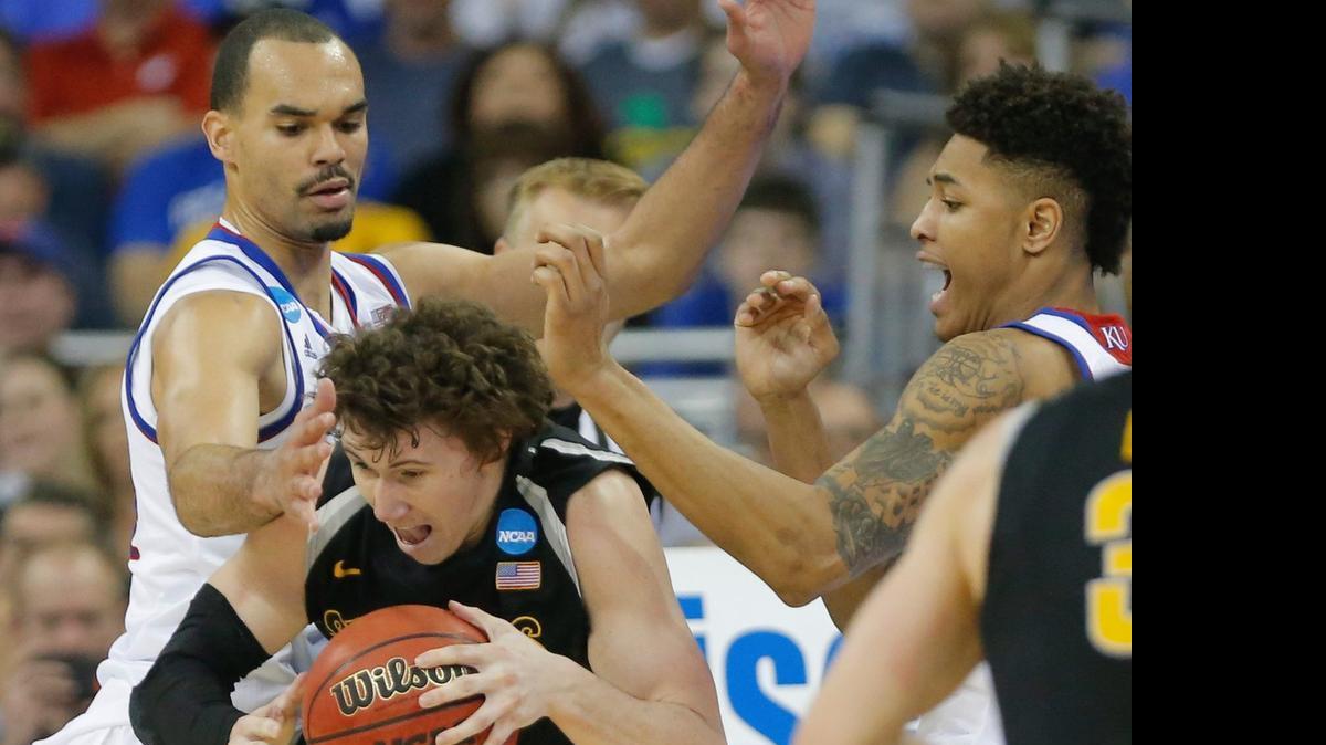 
Wichita State guard Evan Wessel tries to escape from Kansas forward Perry Ellis and guard Kelly Oubre during the first half of last March’s NCAA Tournament third-round game.
