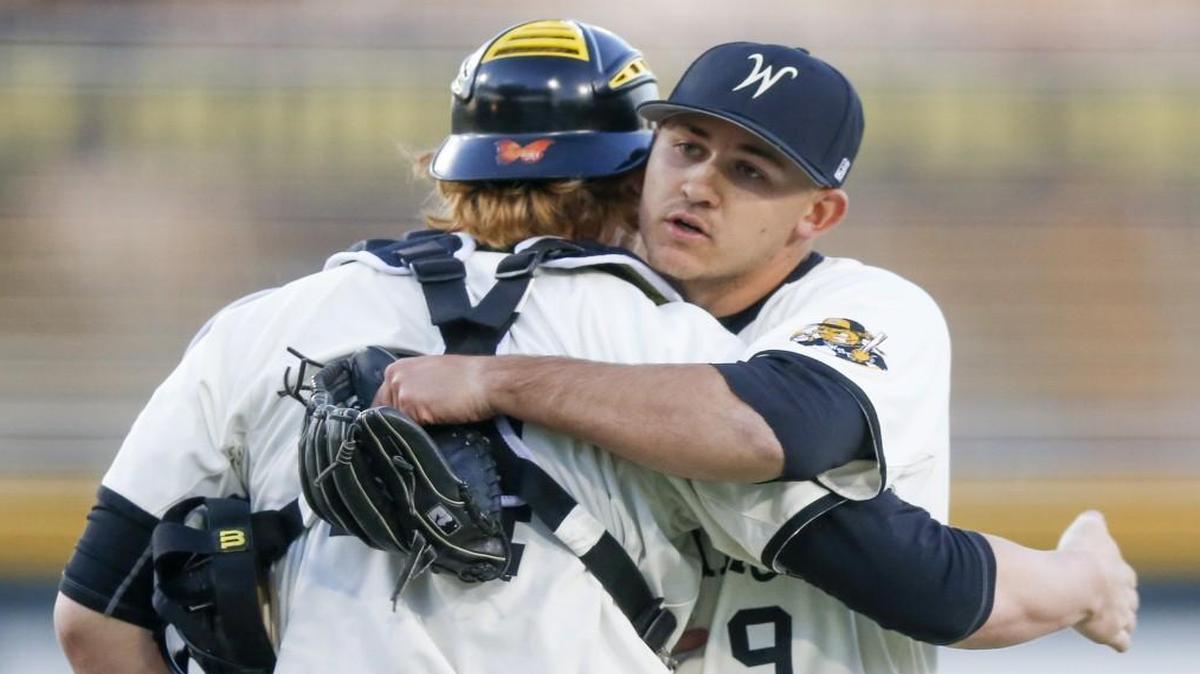 Wichita State reliever Reagan Biechler (9) gets a hug from catcher Gunnar Troutwine after closing out the game against Utah Valley at Eck Stadium Friday. The Shockers won their season opener 4-3.