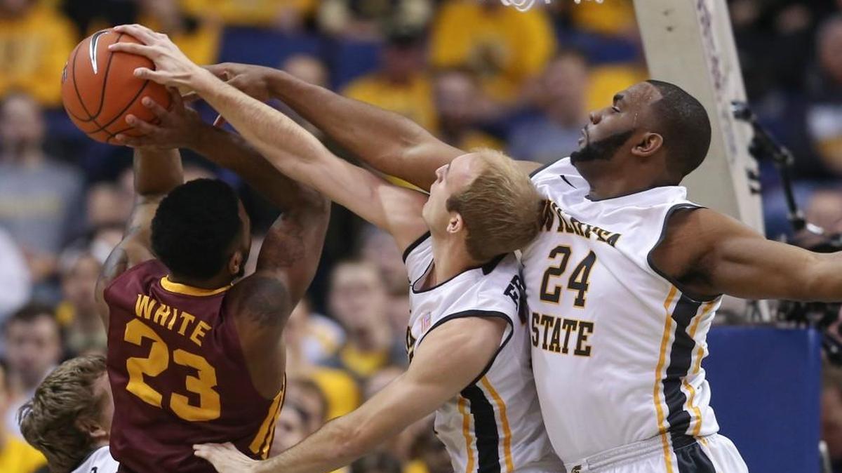 Wichita State forward Shaquille Morris, right, and Conner Frankamp blocks the shot of Loyola guard Jeff White during the first half.