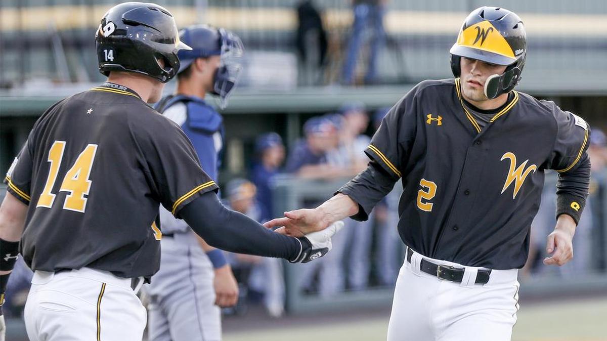 Wichita State's Tanner Kirk (2) gets congratulated by teammate Gunnar Troutwine after scoring in the 1st inning against Oral Roberts at Eck Stadium Tuesday. Wichita State won 15-8. (April 5, 2016)