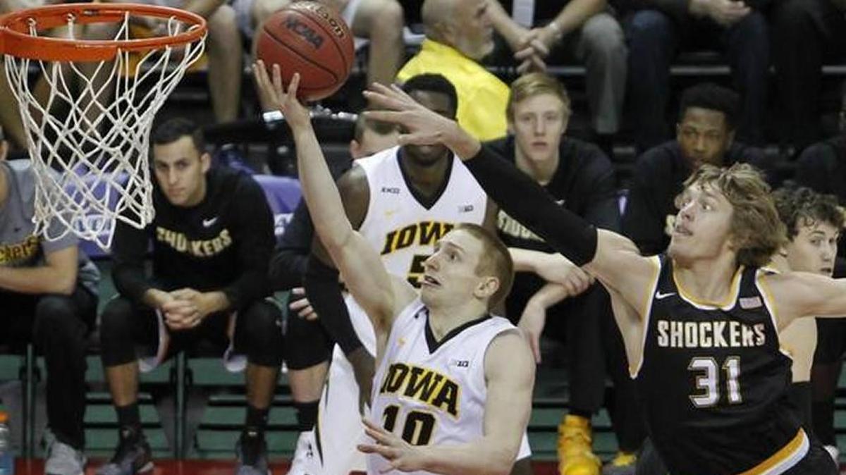 Wichita State’s Ron Baker defends a layup by Iowa’s Mike Gesell during Sunday’s game in the AdvoCare Invitational.
