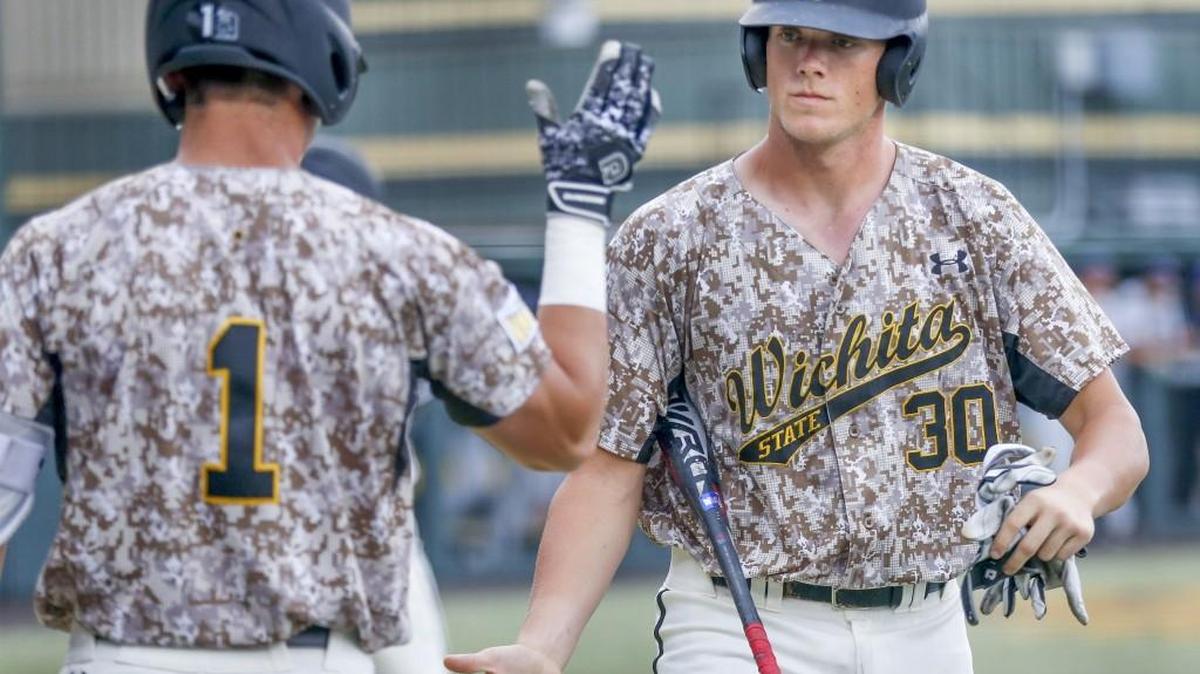 Wichita State's Greyson Jenista, right, gets congratulated by teammate Travis Young after scoring in the fourth inning.