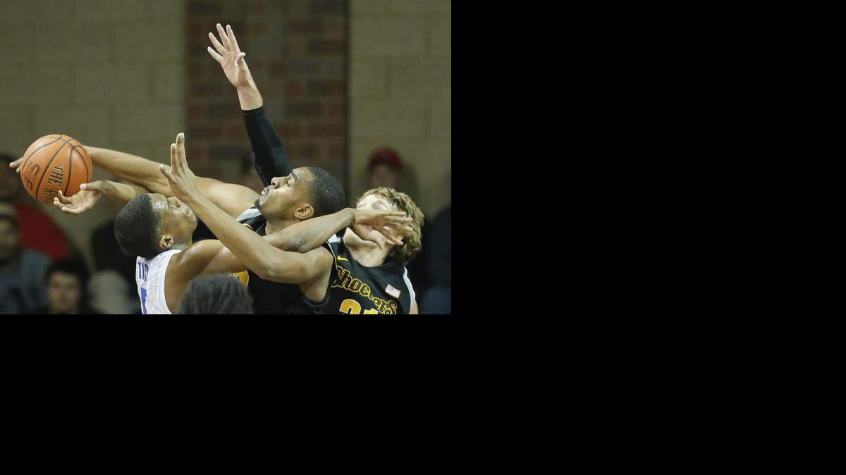 
Wichita State’s Darius Carter and Ron Baker tries to block the shot of Memphis' Nick King during the second half Tuesday.
