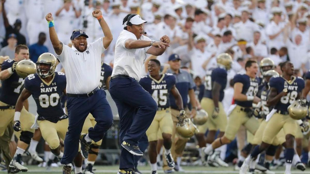 Navy coach Ken Niumatalolo, center, leads a celebration after win over Connecticut in Annapolis, Md.