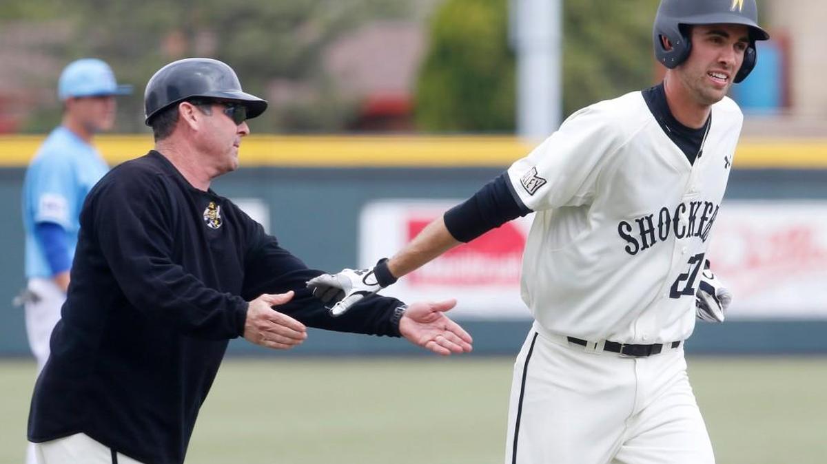 Wichita State’s Ryan Tinkham is congratulated by coach Todd Butler after hitting a two-run home run last April.