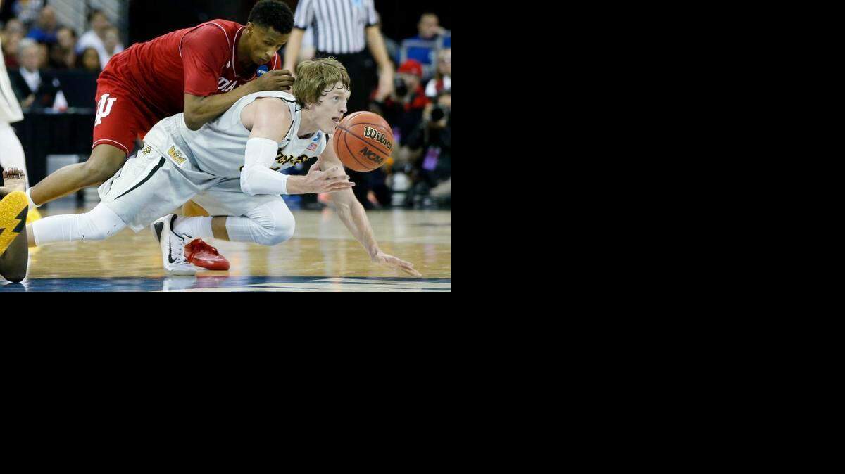 
Indiana forward Troy Williams falls on top of Wichita State guard Ron Baker in their NCAA Tournament game at CenturyLink Center in Omaha. (March 19, 2015)
