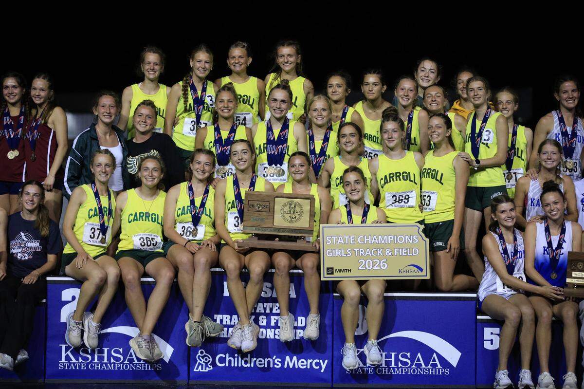 Bishop Carroll’s girls track and field team poses with the Class 5A state championship trophy after winning the program’s first team title since 2011 on Saturday at Crossland Stadium in Wichita.