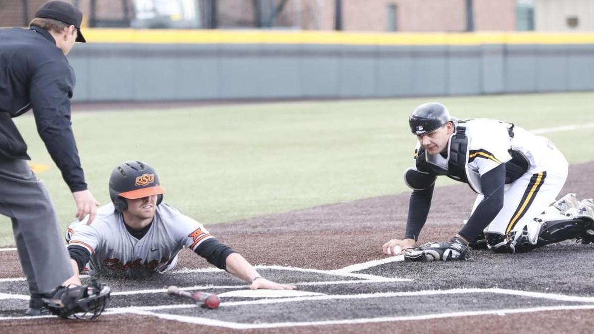 Oklahoma State catcher Michael Neustifter slides into home base while Wichita State catcher Noah Croft tries to tag him out in the second inning during Wednesday's game in Eck Stadium.