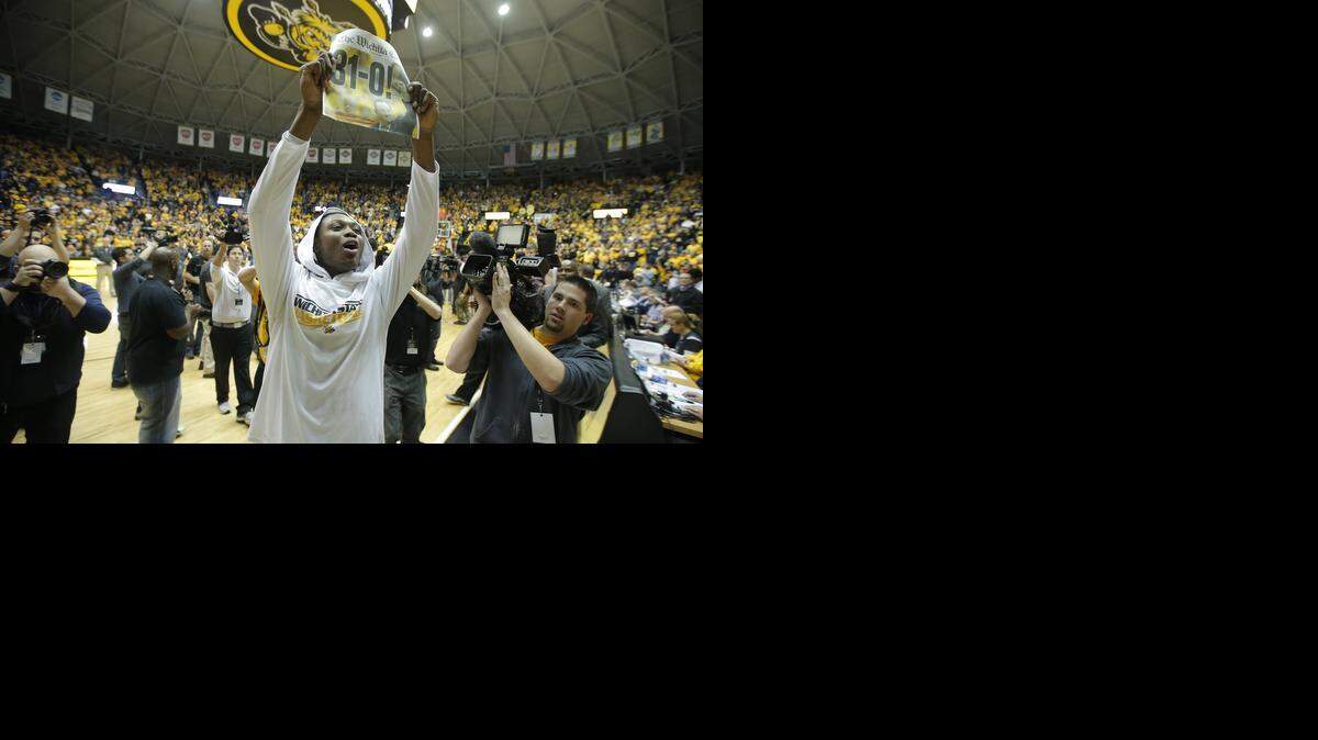 
Wichita State's Cleanthony Early holds up a commemorative newspaper after the Shockers beat Missouri State 68-45 to wrap up a 31-0 regular season in 2013-14.

