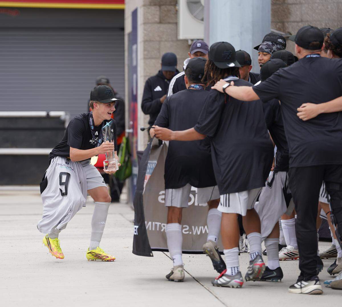Sporting Wichita Academy’s U15 boys team celebrates with the MLS Next Cup trophy after winning the national championship Saturday in Salt Lake City, completing a perfect 28-0 season.