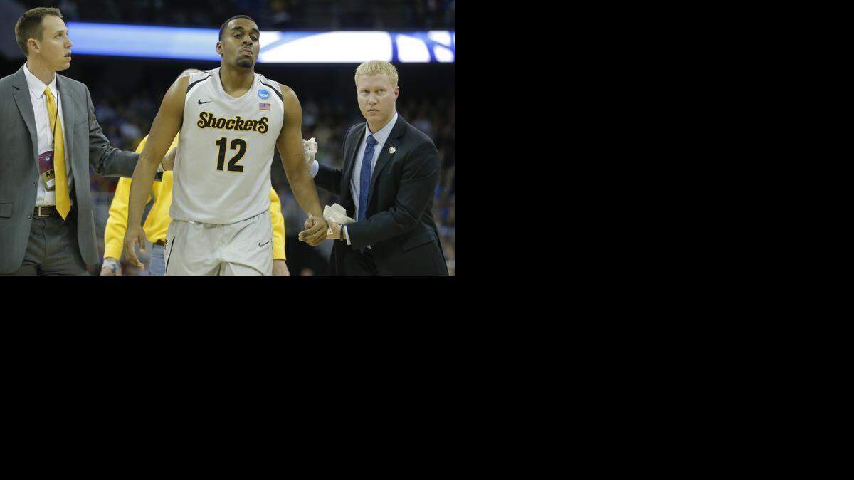
Wichita State’s Darius Carter is helped off the court after he was hit in the mouth during the second half against Indiana on Friday.
