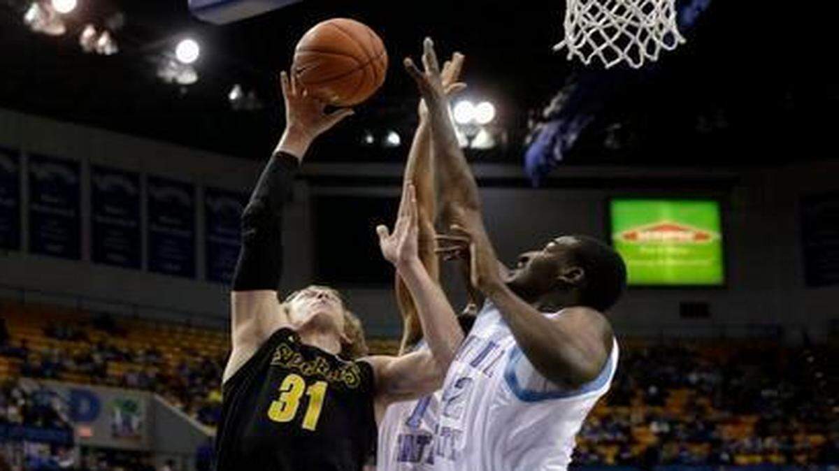 
Wichita State guard Ron Baker, left, shoots over Indiana State forward T.J. Bell in the first half Wednesday.
