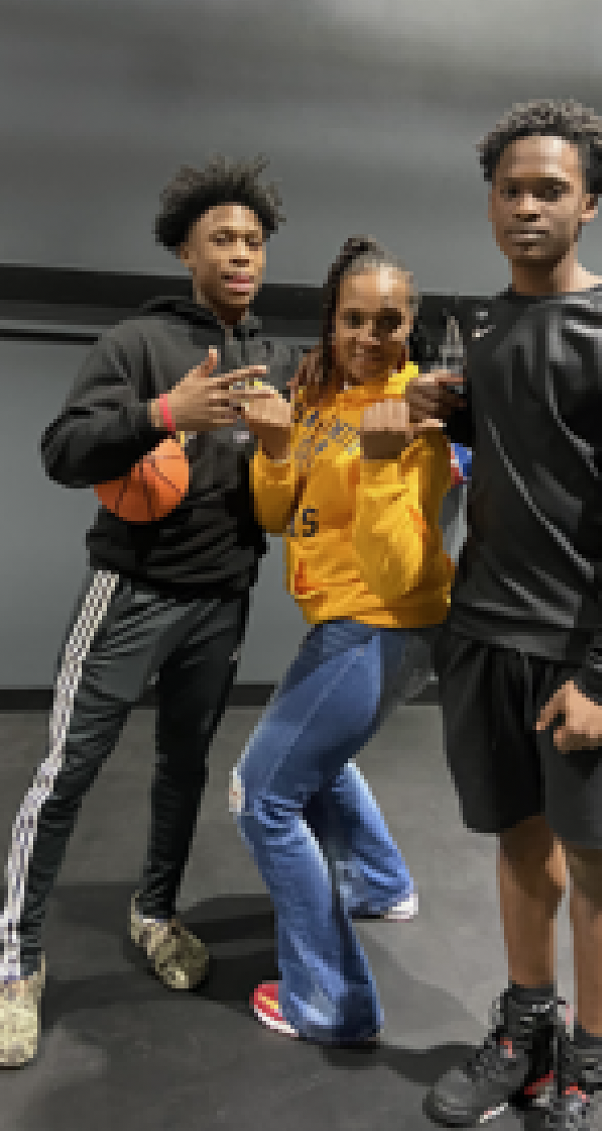 Kenyon Giles (left) and Kanye Clary (right) pose for a picture when they are in high school with Giles’ mother, Sharonda Street, pictured in the middle.