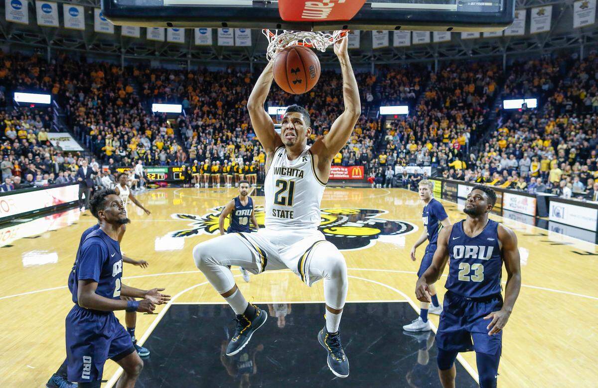 Wichita State forward Jaime Echenique dunks over Oral Roberts forward Emmanuel Nzekwesi, right, during the first half Wednesday at Koch Arena.