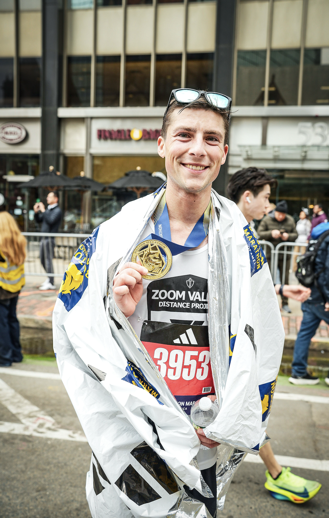 After finishing the Boston Marathon in a personal-best time, Father Seth Arnold shows off his medal.