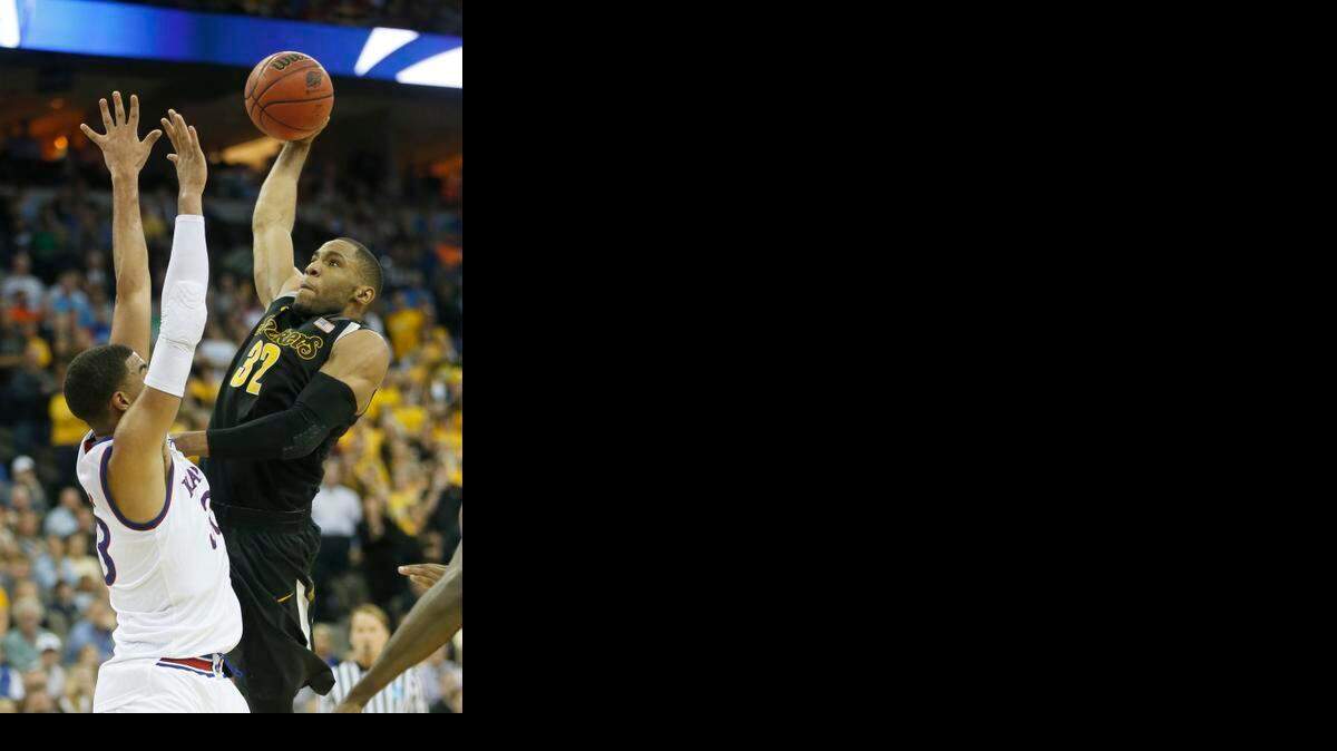 
Wichita State guard Tekele Cotton attempts to dunk over Kansas forward Landen Lucas in the first half. Cotton drew the foul and the ball went in for an eventual three-point play that tied the score 26-all.
