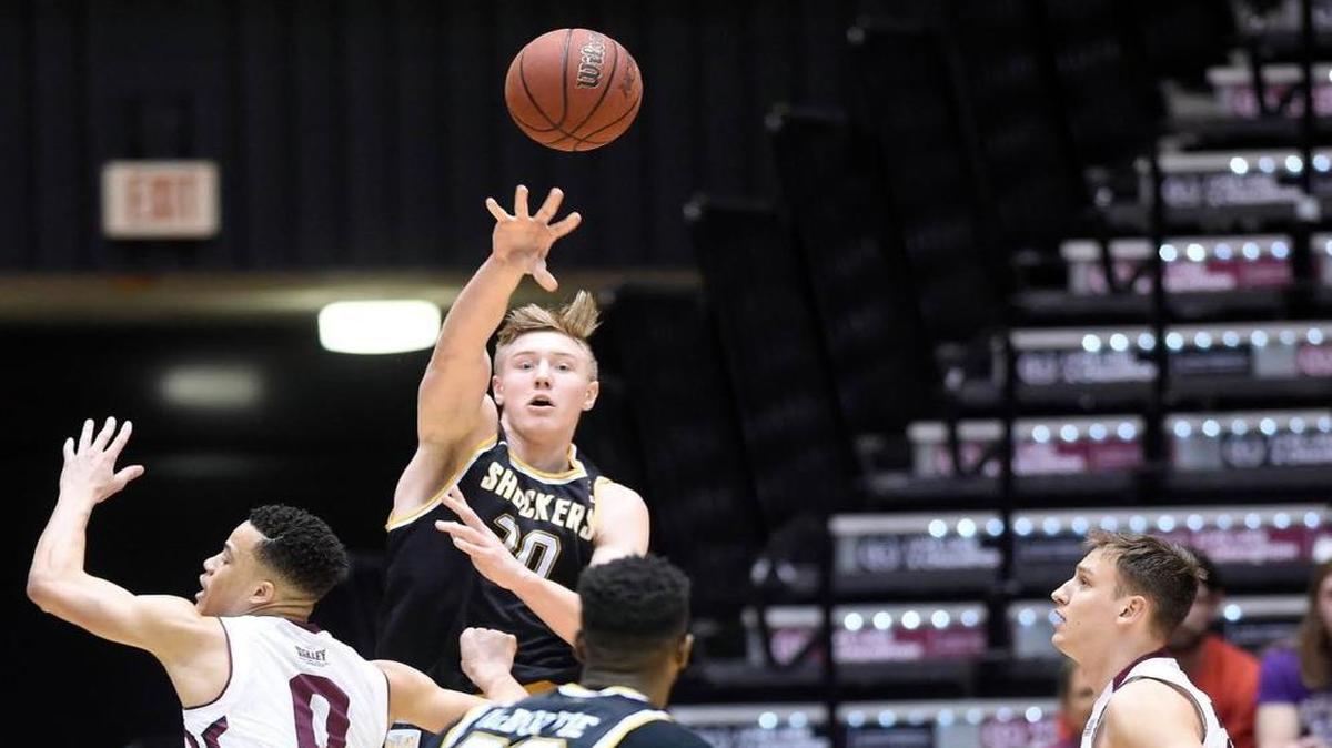 Wichita State center Rauno Nurger passes to forward Markis McDuffie between SIU guard Jonathan Wiley, left, and forward Rudy Stradnieks during the first half Wednesday at SIU Arena in Carbondale, Ill.