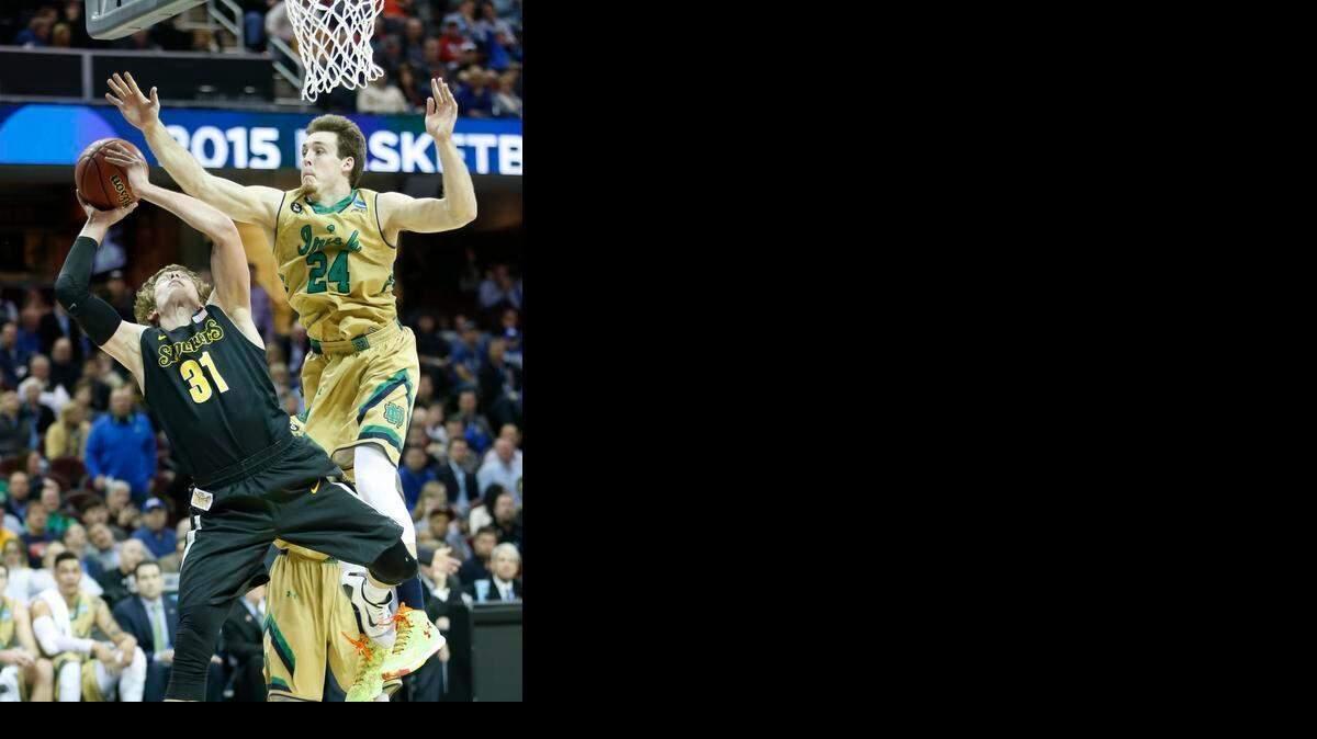 
Wichita State guard Ron Baker is fouled by Notre Dame’s Pat Connaughton during the first half Thursday night in Cleveland.
