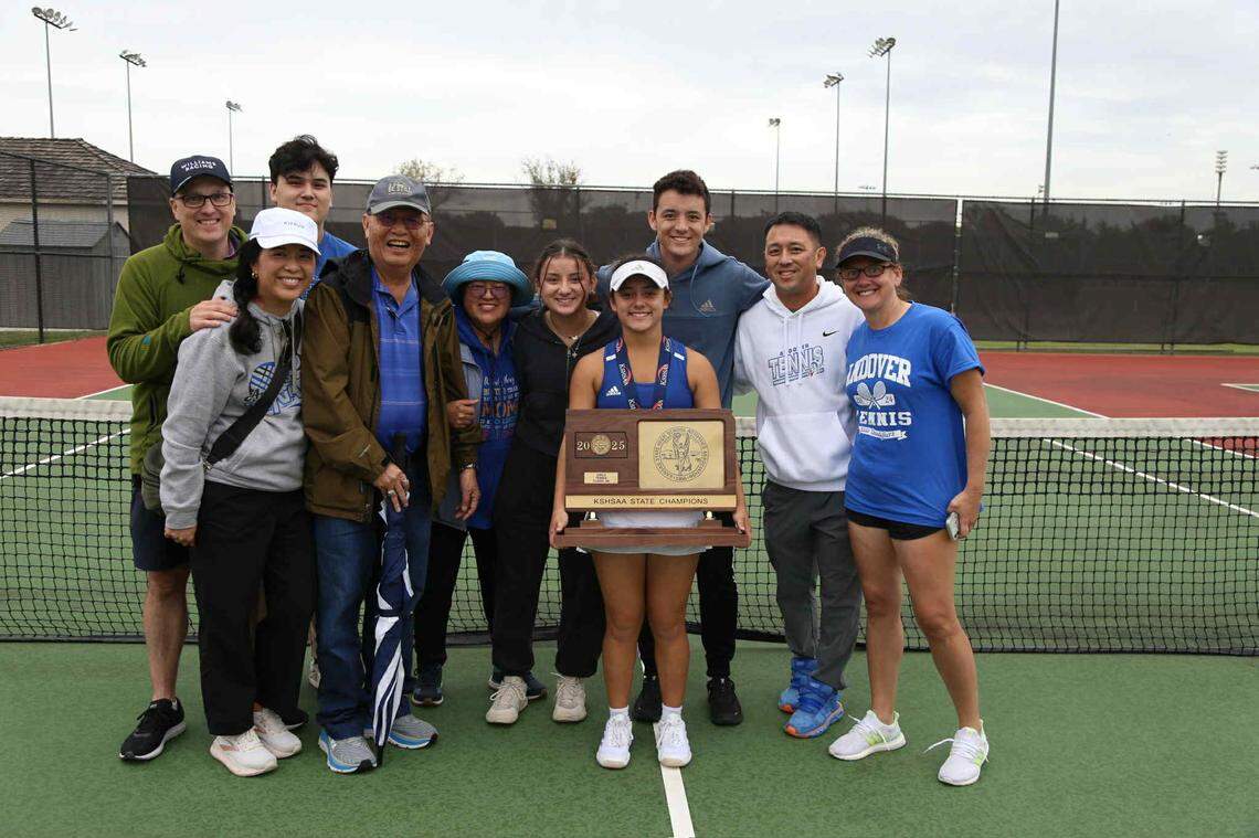 Andover senior Emma Jittawait poses for a picture surrounded by family with the Class 5A team championship after helping the Trojans win again with her doubles partner, Ada Tantemsomboon.