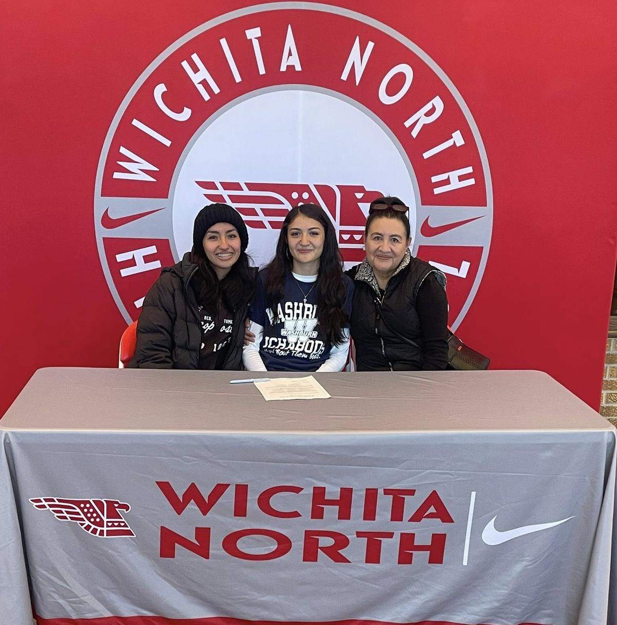 Wichita North senior Nelly Puente is joined by her older sister Dennys and mother Elida on signing day, when Puente made official her commitment to run track and cross country at Washburn University.
