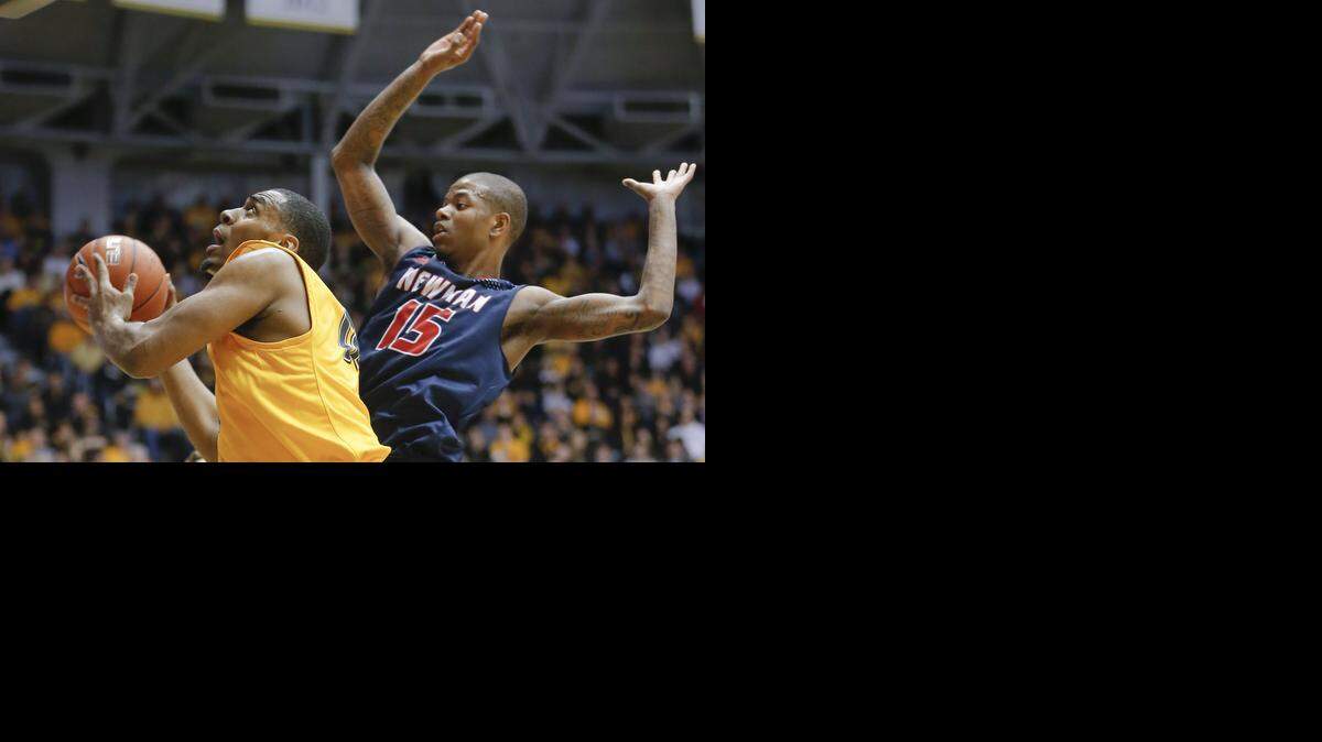 
Wichita State's Darius Carter glides past Newman University's Reggie Baker during the first half of their game at Koch Arena on Sunday. (Nov. 23, 2014)
