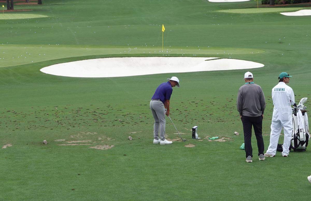 Wichita native Sam Stevens works on the practice range at Augusta National with his father, Charlie, watching.