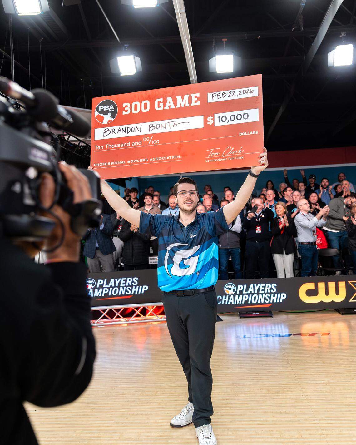 Wichita native Brandon Bonta holds up his check for rolling a perfect game of 300 in the televised finals of the PBA Players Championship in Arlington, Texas on Sunday.