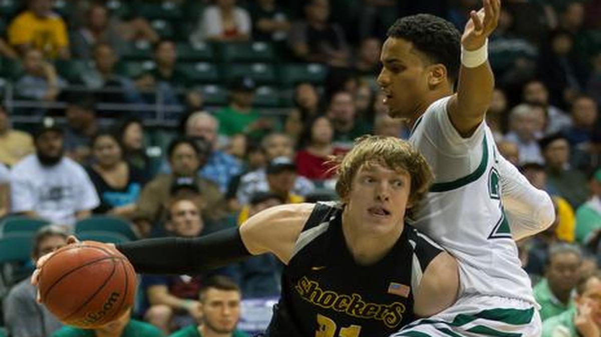 
Wichita State guard Ron Baker drives the baseline while being defended by Hawaii guard Aaron Valdes in the first half of Tuesday’s game at the Diamond Head Classic in Honolulu. 
