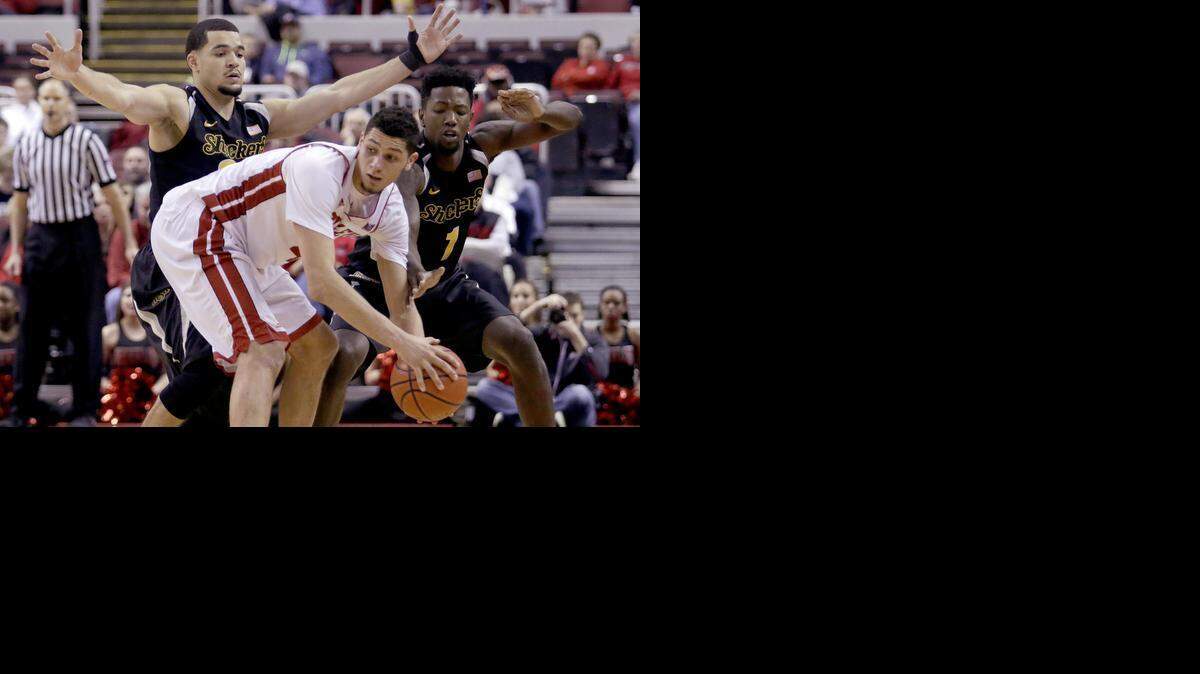 
Wichita State guard Fred VanVleet (23) and forward Zach Brown (1) defend against Bradley forward Auston Barnes (4) during the second half of an NCAA college basketball game Wednesday, Feb. 4, 2015, in Peoria, Ill. Wichita State won the game 62-59. (AP Photo/ Stephen Haas) 
